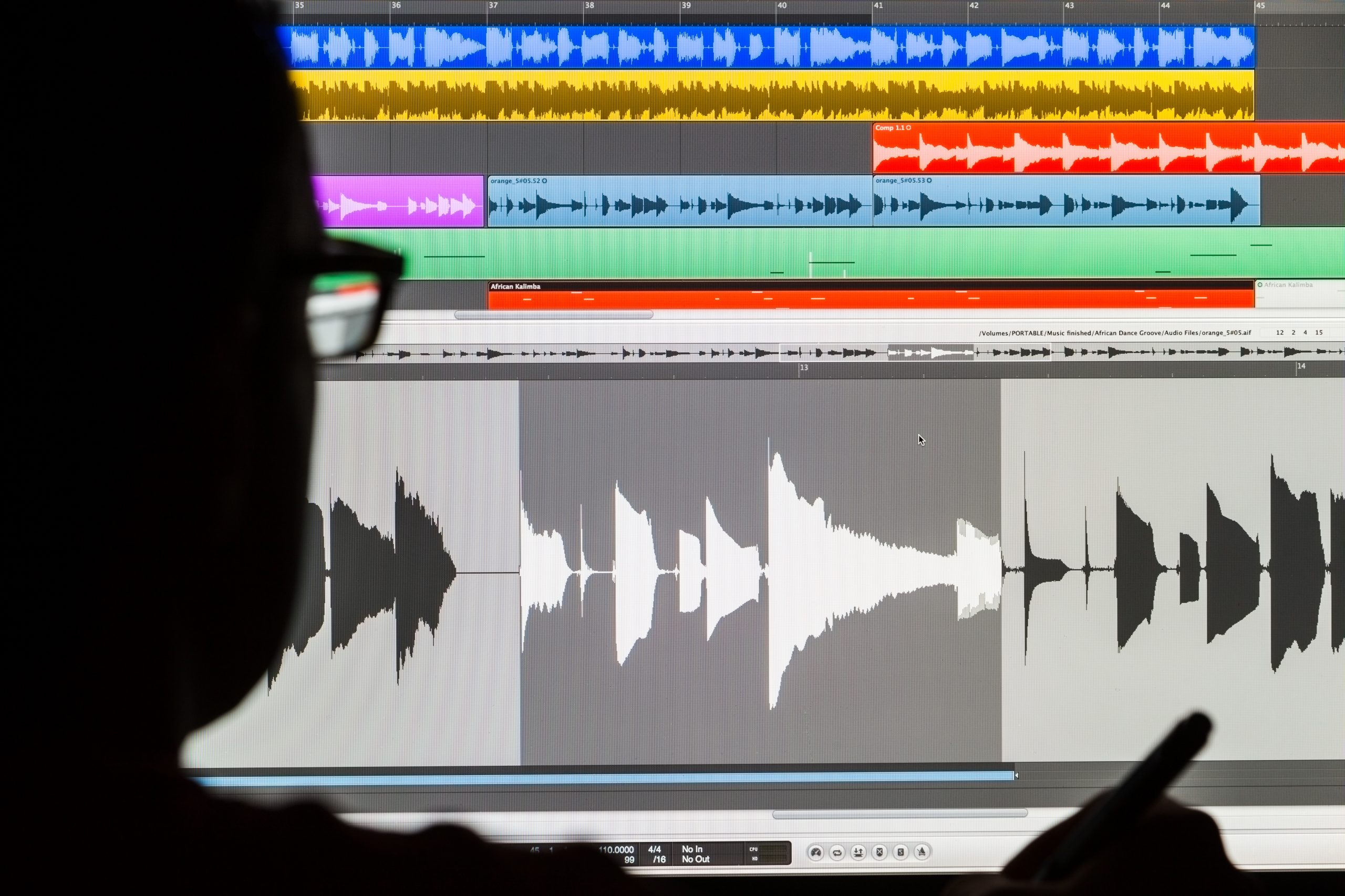 silhouette of man's head looking at screen, editing audio