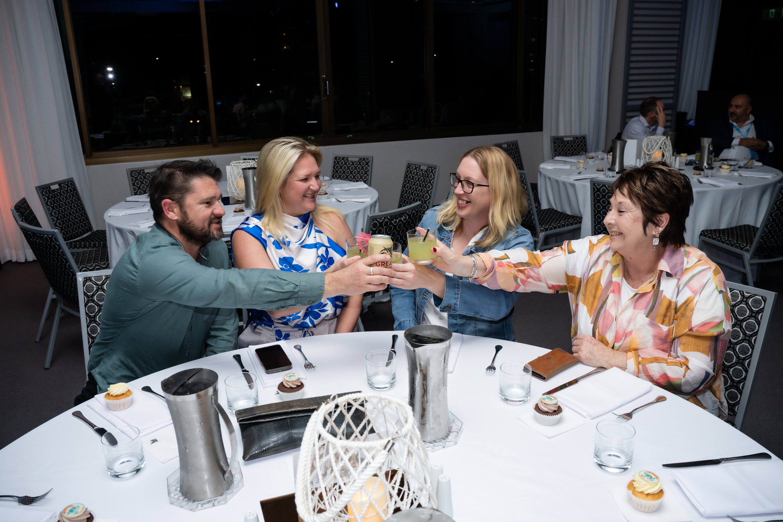 group of people toasting drinks at their table