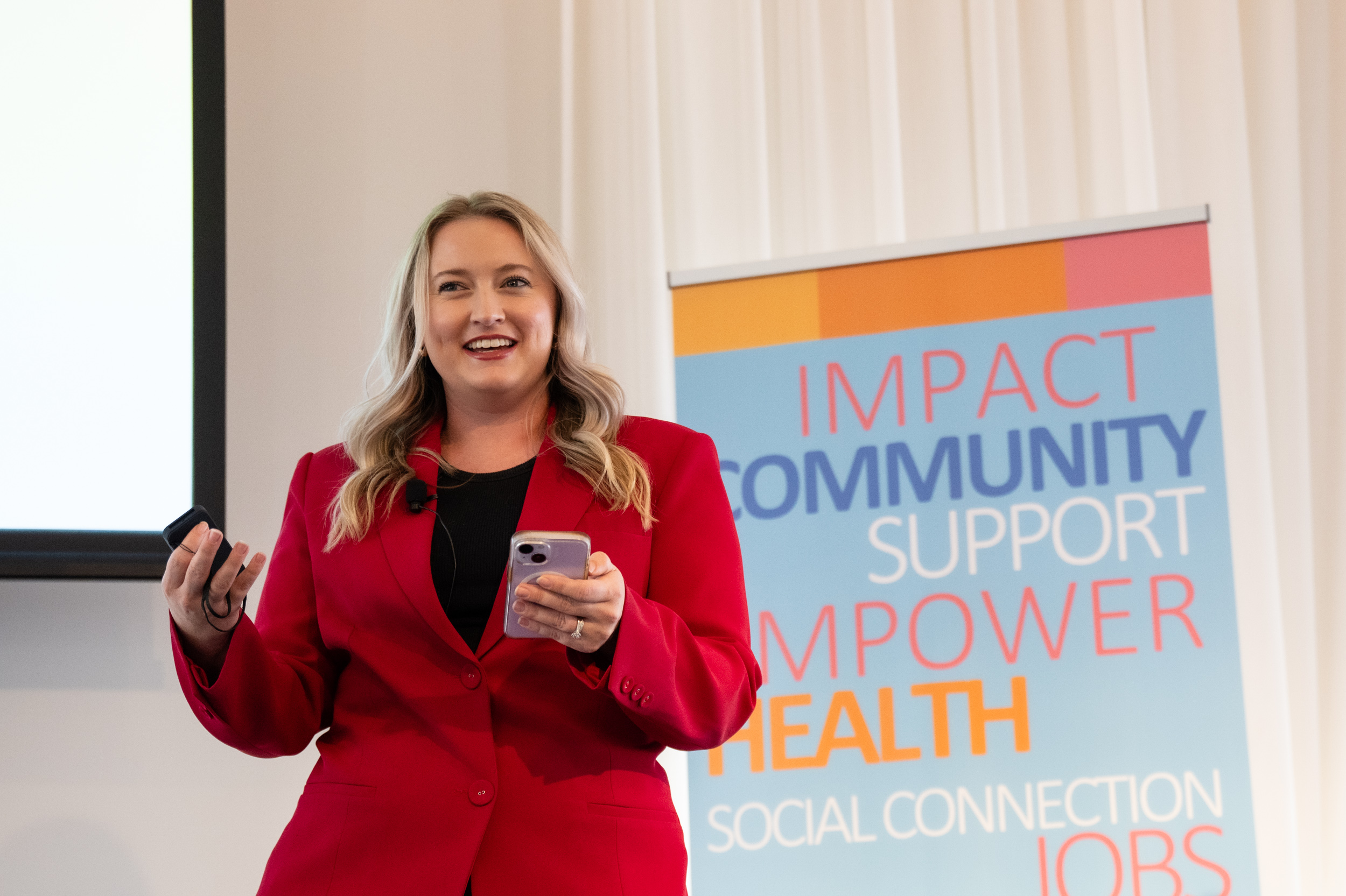 woman in red blazer speaking into mic